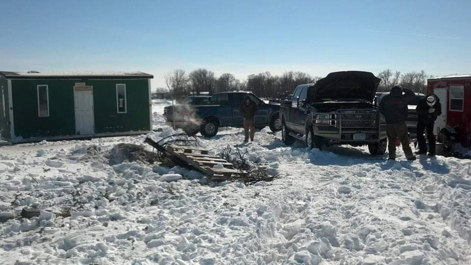 Fish house and trucks on the lake ice